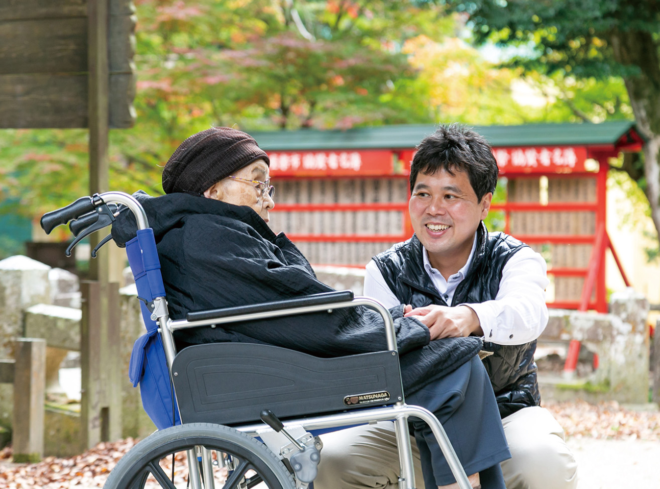 車椅子の利用者様と語らう松山てっぺい（介護現場の様子）